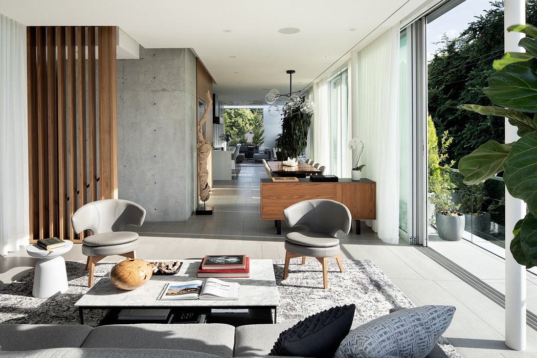 Sleek modern home with concrete walls, wood accents, and large windows overlooking greenery.