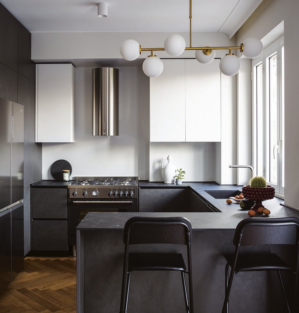 Sleek, modern kitchen with black cabinetry, brass lighting fixtures, and minimalist style.