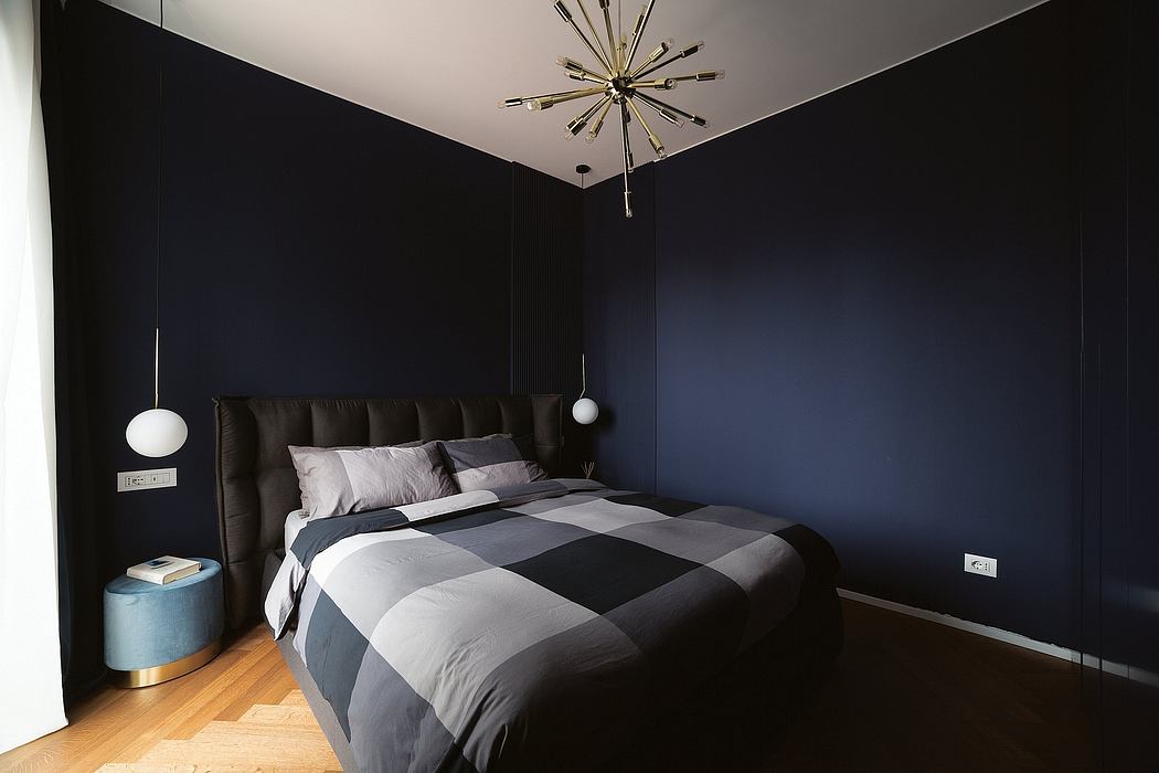 Sleek, contemporary bedroom interior with dark walls, modern light fixture, and plaid bedding.