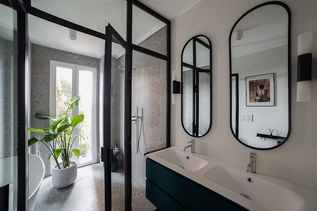 A modern bathroom with black metal frames, large mirrors, and a potted plant.