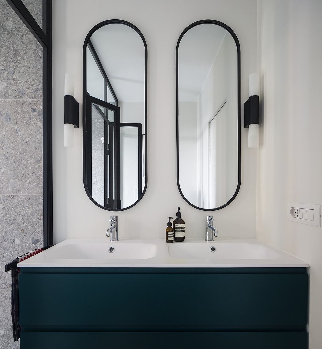 Sleek black framed mirrors and modern vanity with minimalist decor in bathroom.