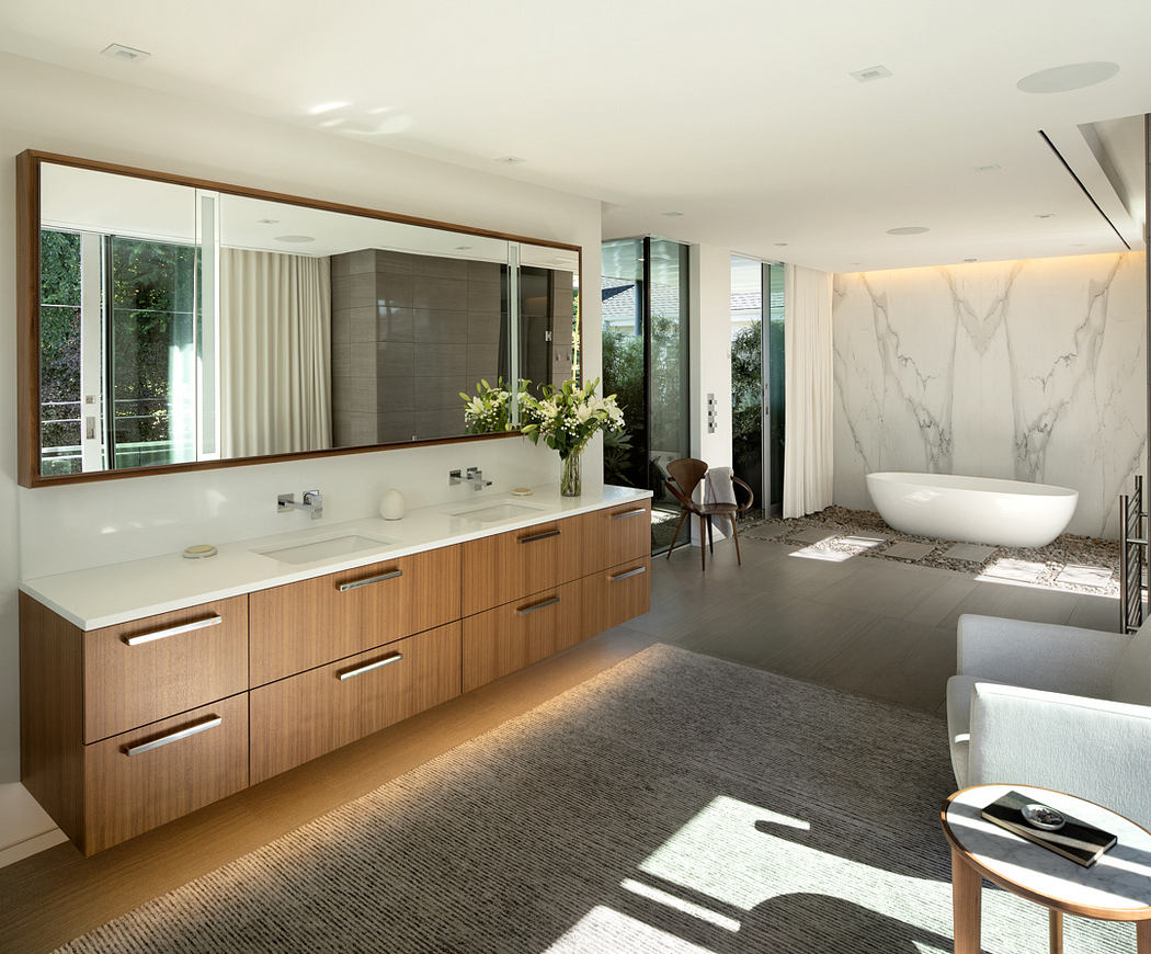 Spacious modern bathroom with wooden vanity, marble accents, and large mirror.