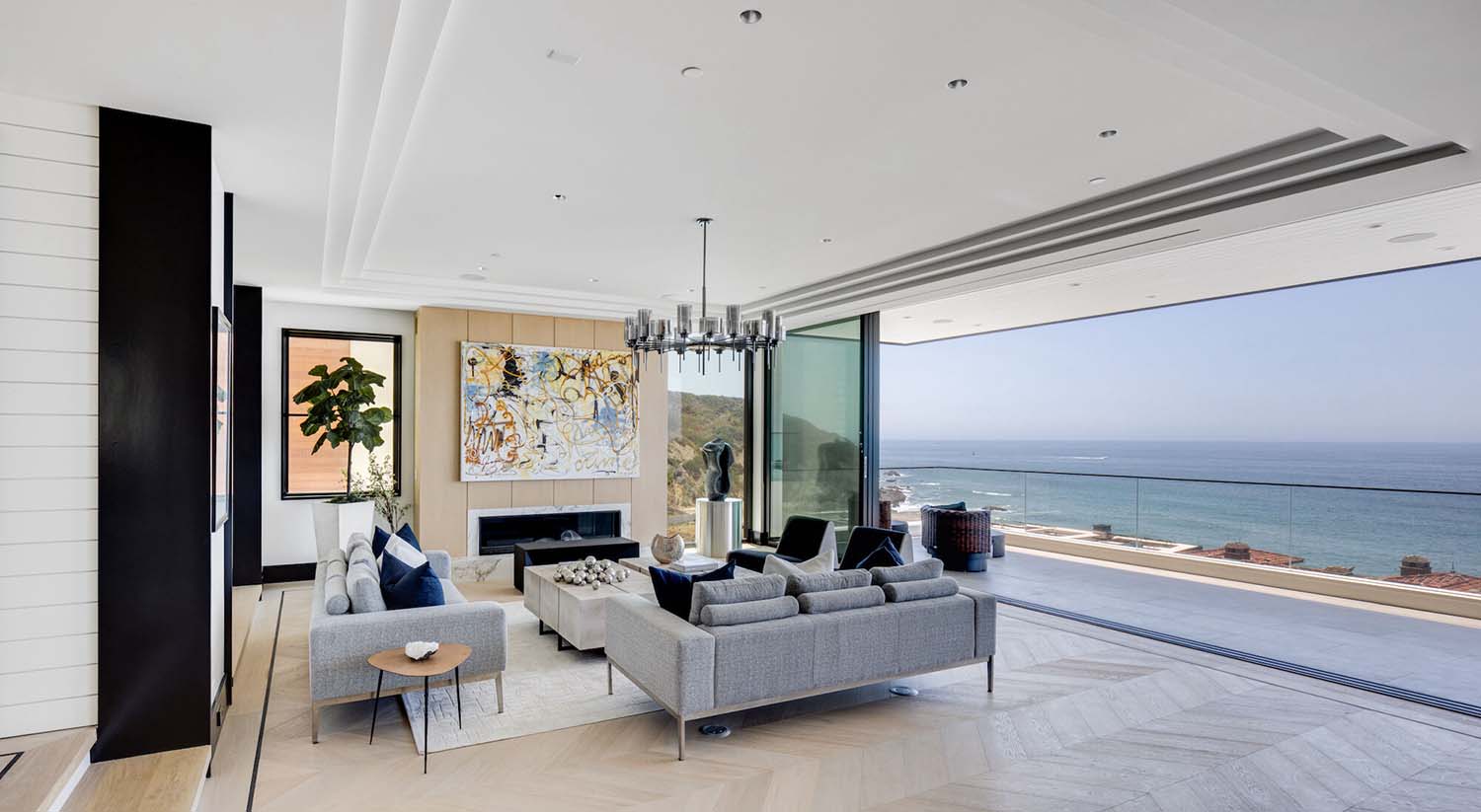 coastal contemporary living room with a sliding glass door that opens to the ocean