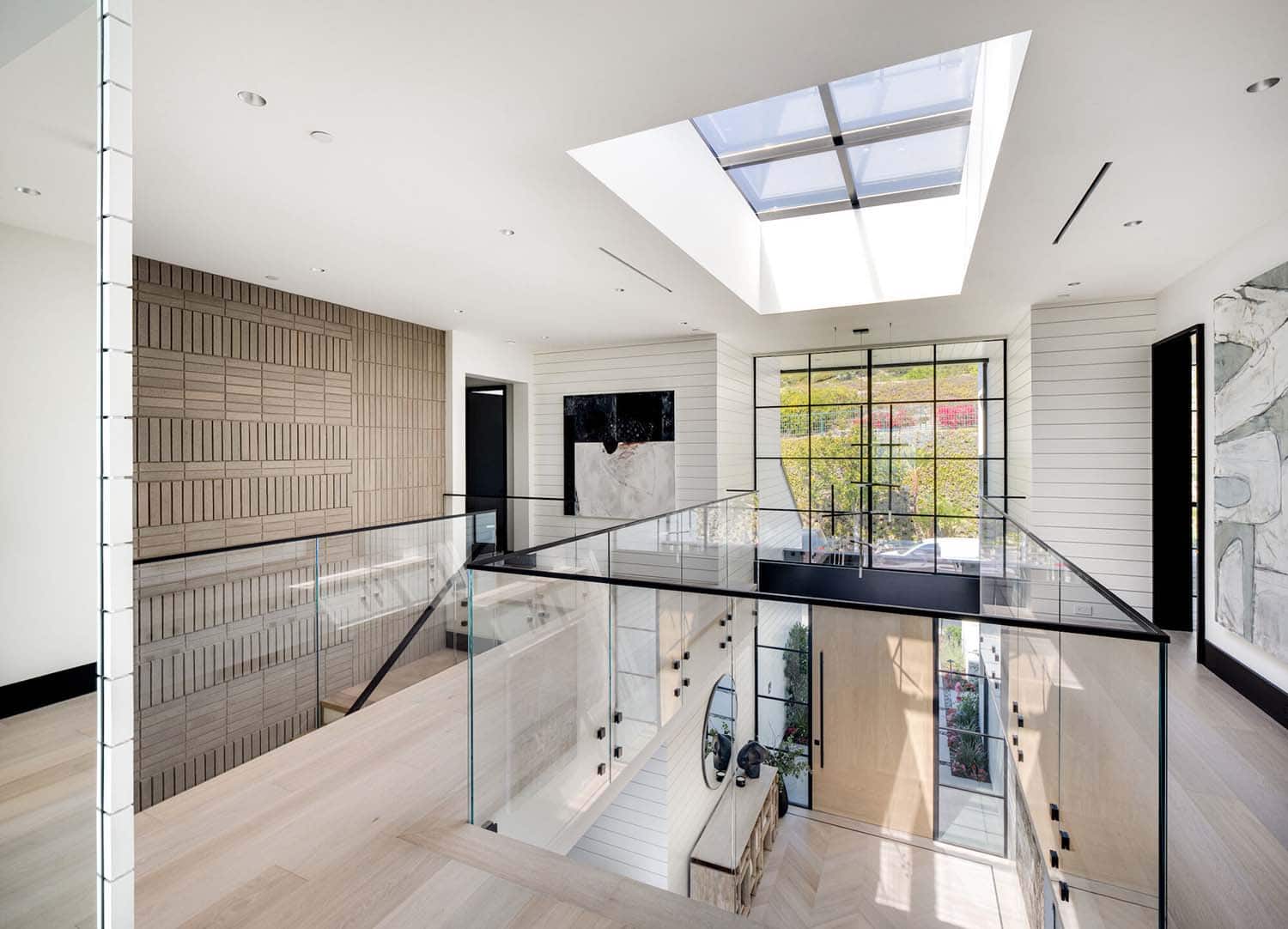 coastal contemporary upstairs hallway with a glass guardrail