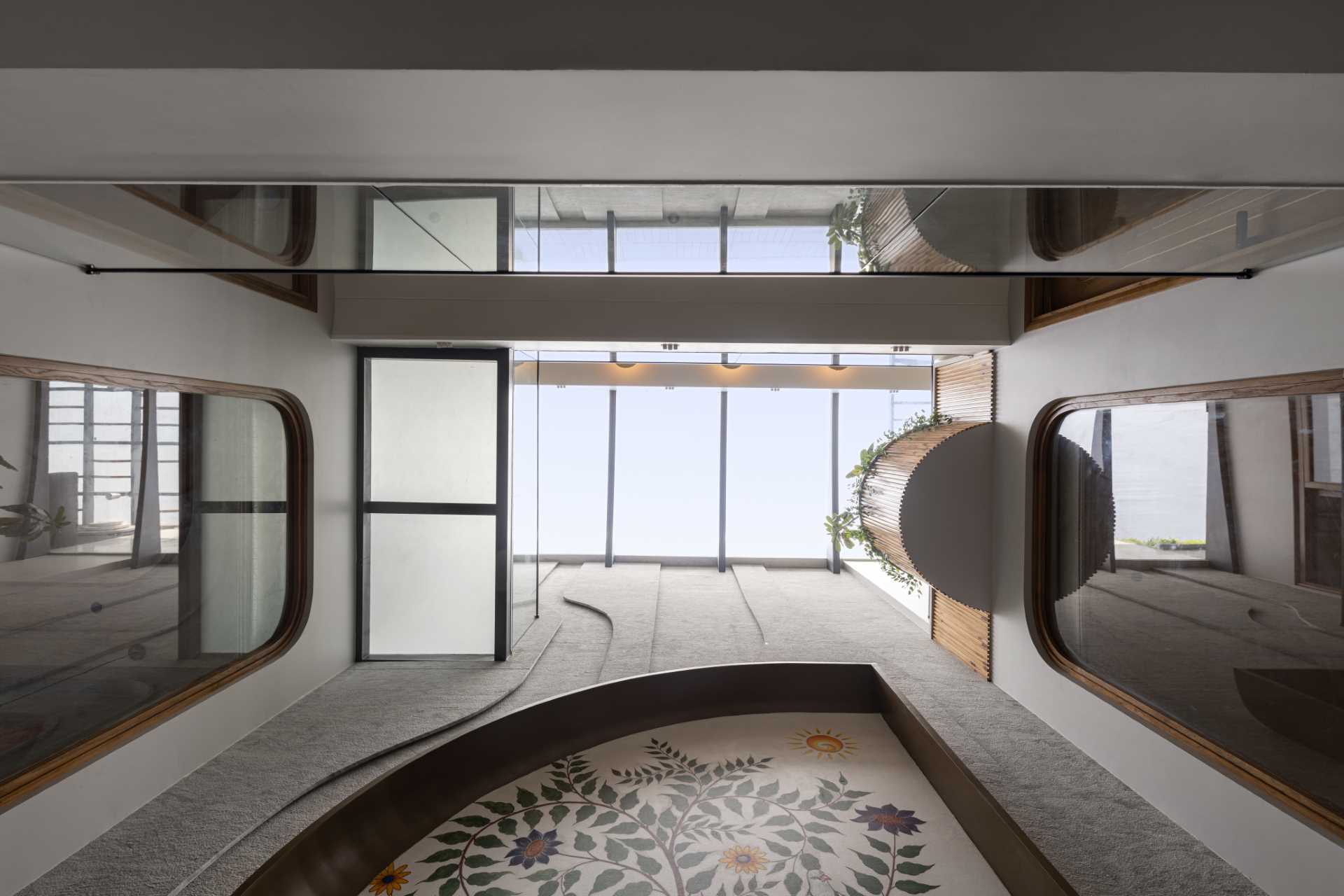 A tall and narrow house with a large colorful wall mural highlighted by a skylight.