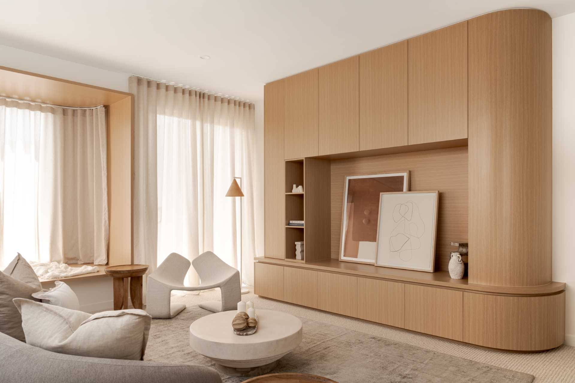 In this retreat room, there's a wall of custom wood cabinetry, a lounge area, and a wood-lined window seat.