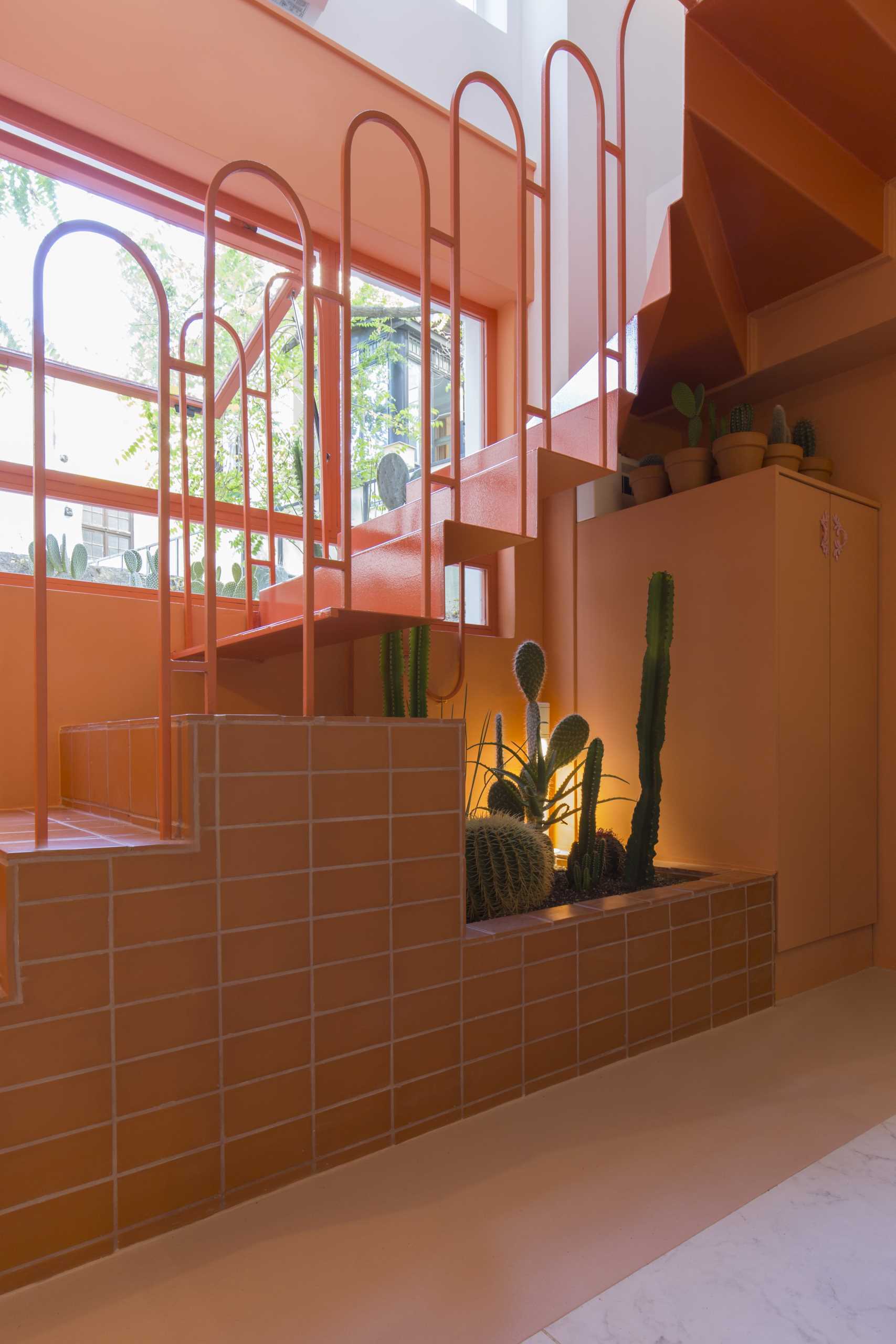 A modern retail store with a monochromatic terracotta interior that also includes built-in planters for cacti.